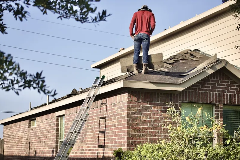 Professional roofer working on a residential roof in Etta